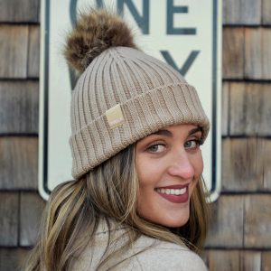 Woman wearing an oatmeal ribbed knit beanie with pom
